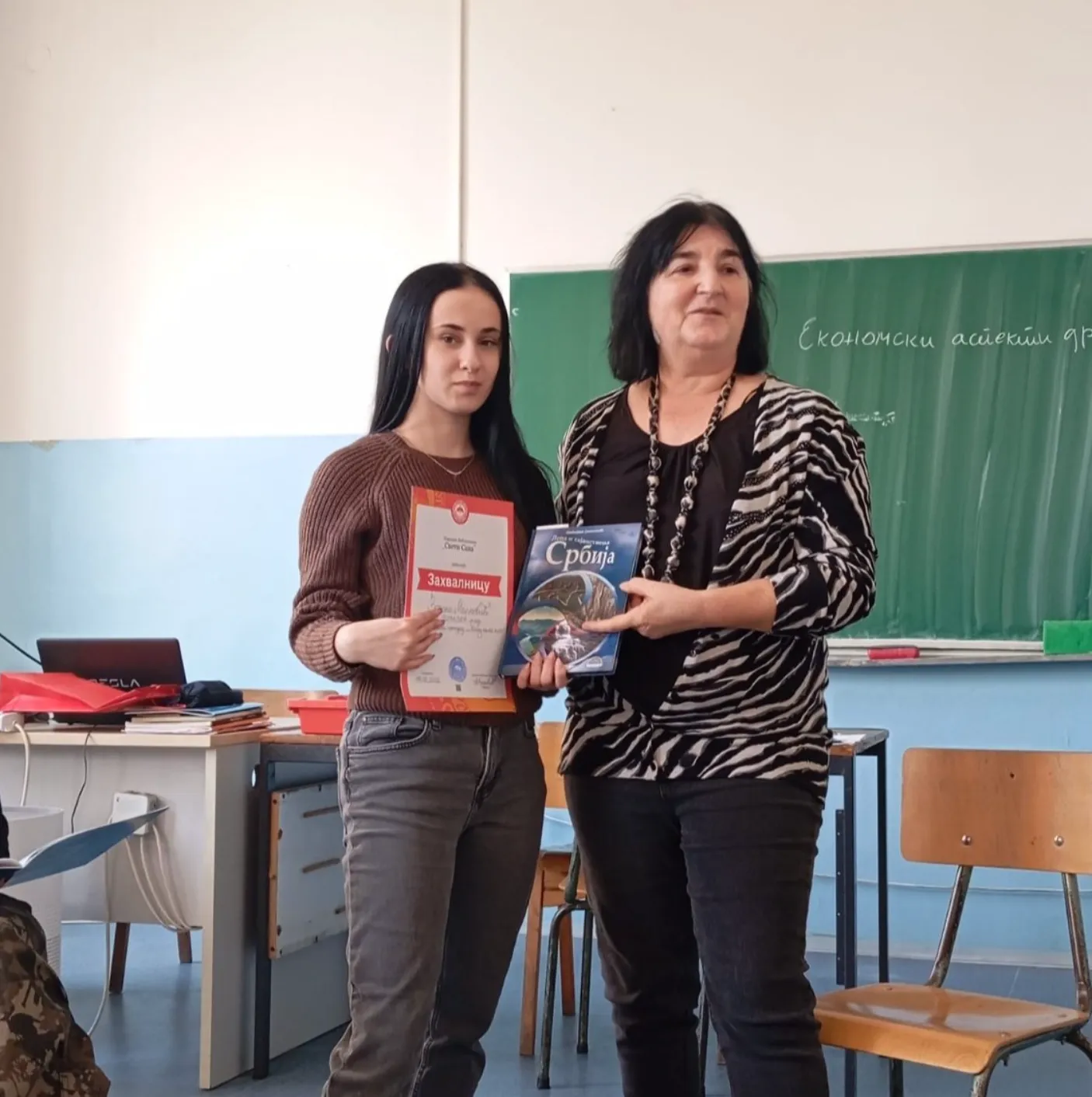 Ученица са захвалницом и наставница у учионици