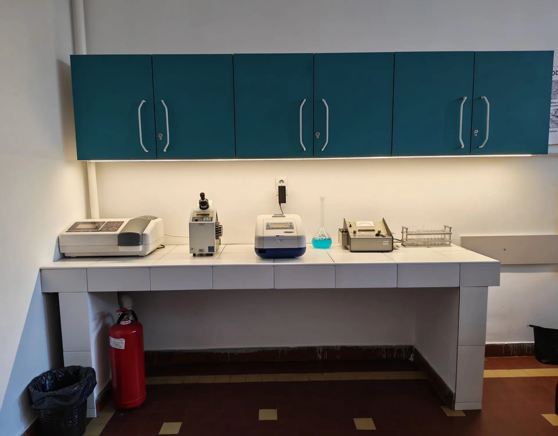 Лабораторијски пулт са инструментима и плавим раствором бакар-сулфата