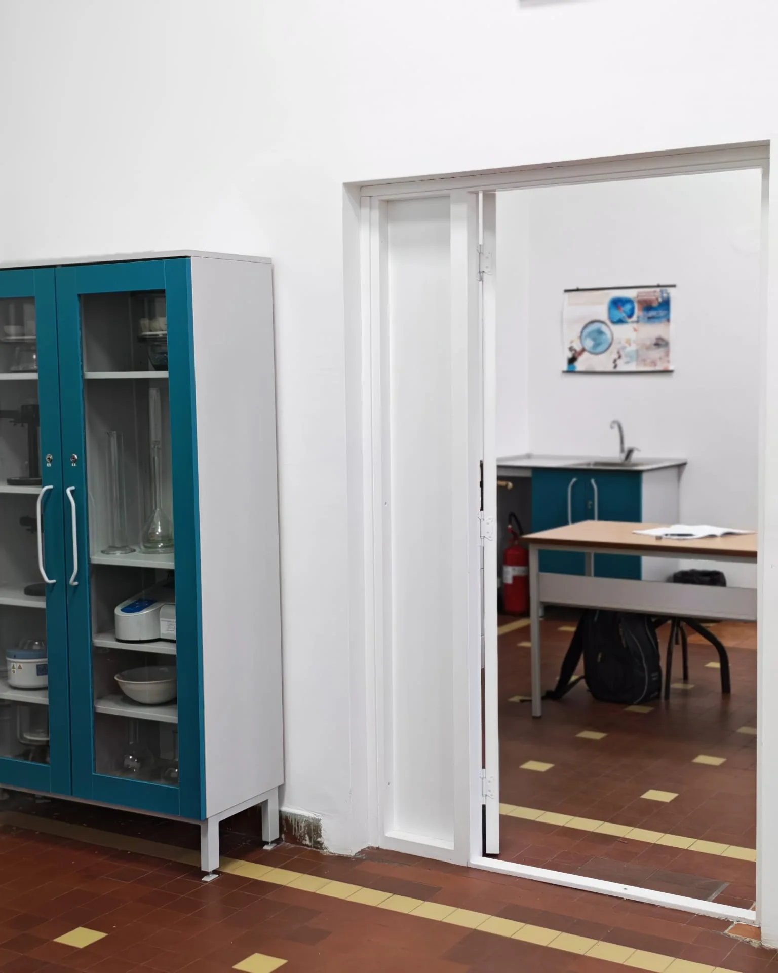 Стаклена витрина са лабораторијском опремом и улаз у суседну учионицу