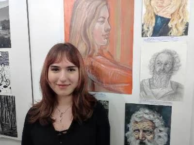 Ученица Азра Илијази испред својих ликовних радова на изложби у галерији Дечијег културног центра