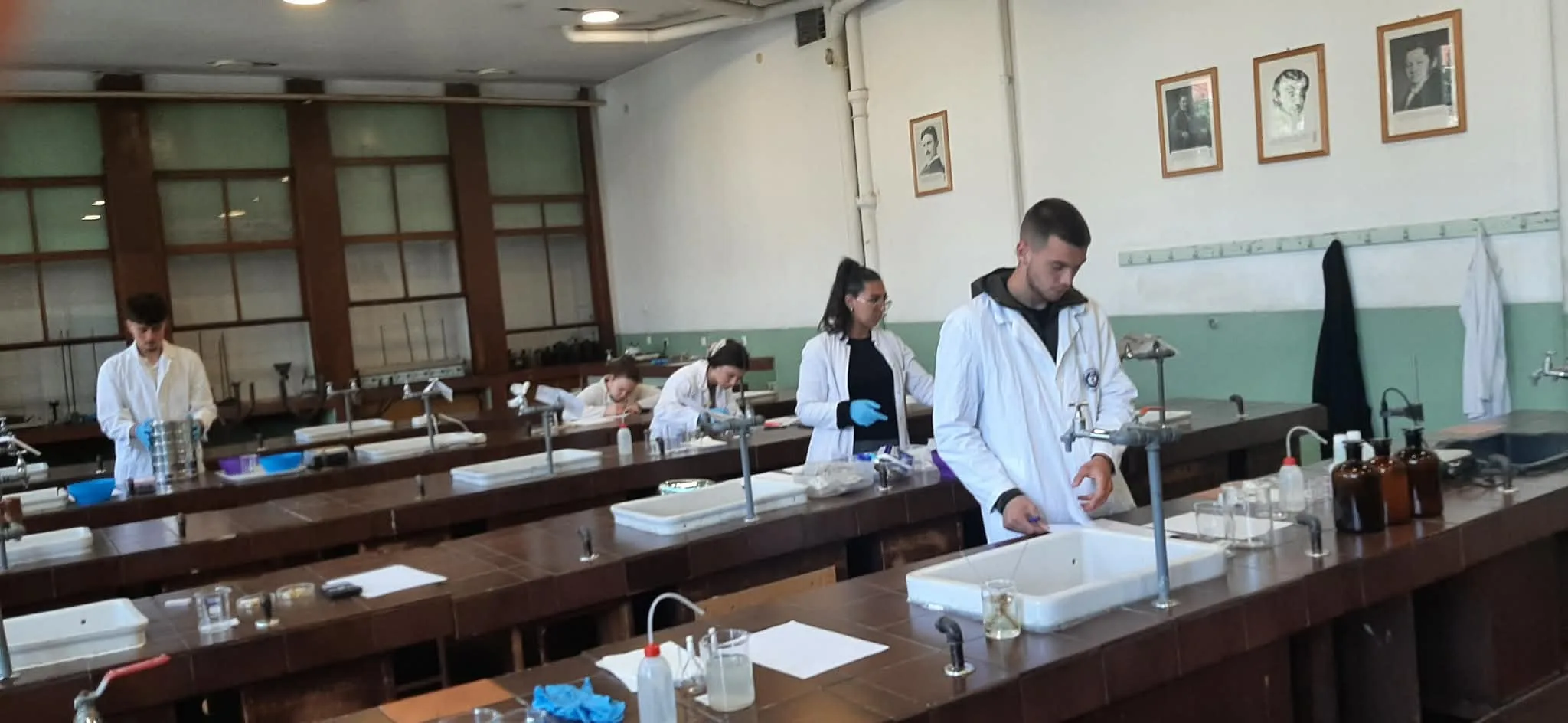Ученик у заштитним рукавицама изводи ситуну анализу помоћу комплета лабораторијских сита током завршног испита