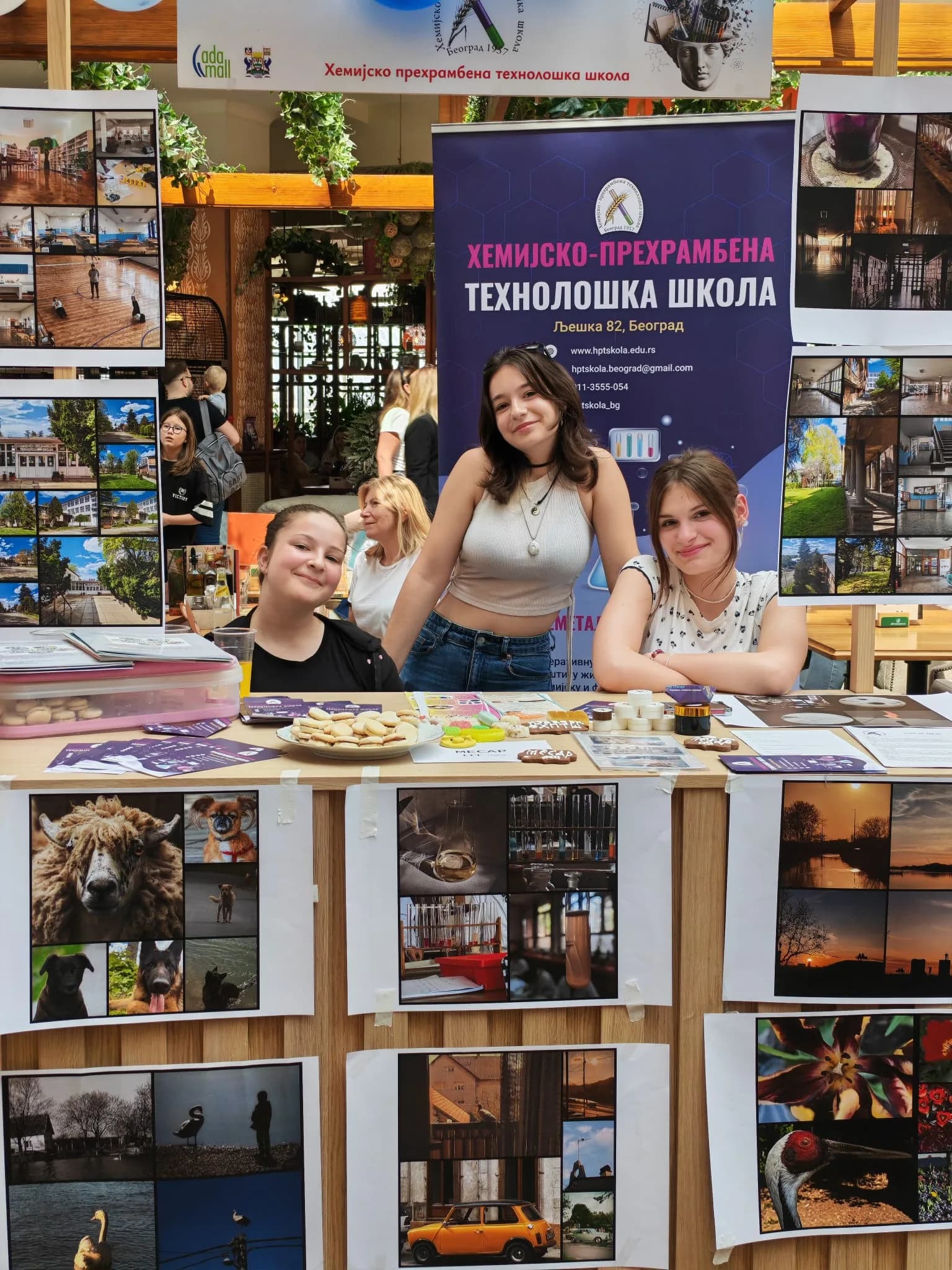 Три ученице ХПТШ испред изложбе фотографија ученика на Сајму образовања