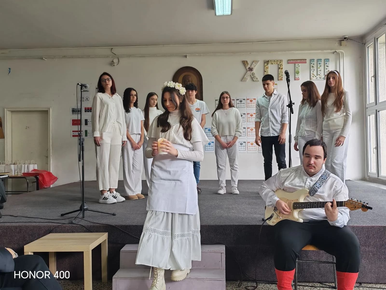 Ученица у белој народној ношњи са свећом, током наступа драмске секције
