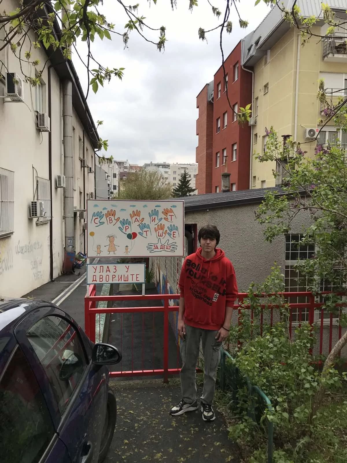 Ученик ХПТШ испред улаза у двориште Свратишта за децу са прикупљеном донацијом